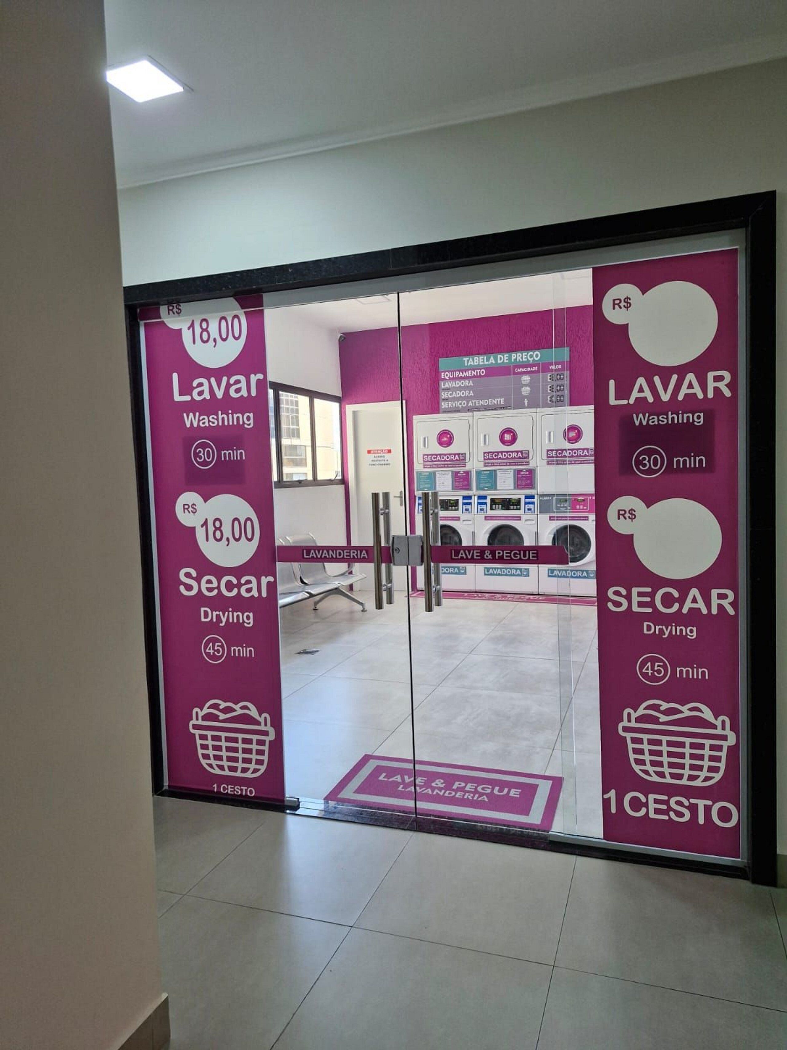Entrada de un hotel con un cartel que detalla el precio y la duración de los servicios de lavandería y tintorería.