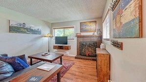 Una sala de estar acogedora con chimenea, televisor y sofá.