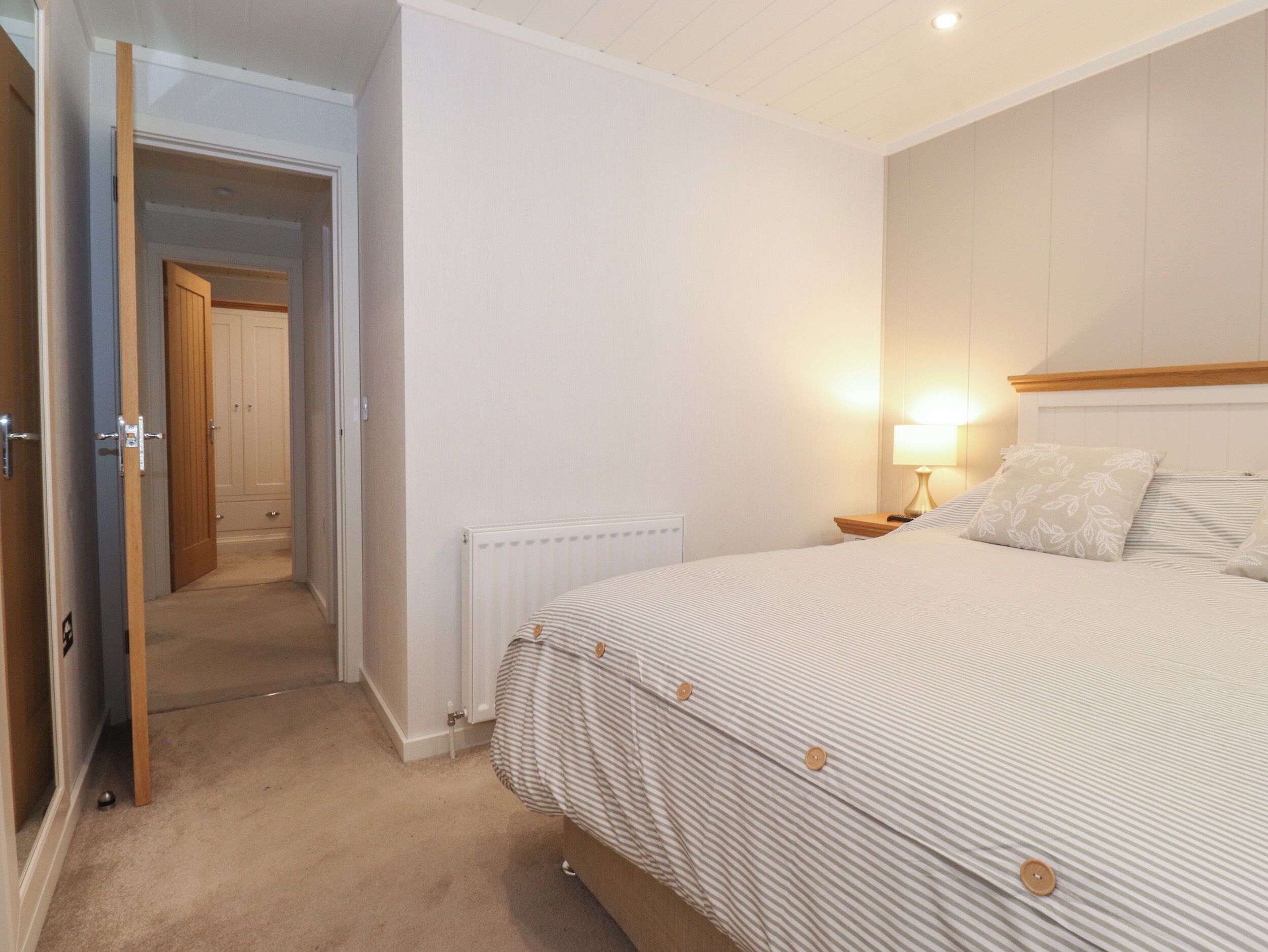 Une chambre à coucher avec un lit, une table de chevet, une lampe et un radiateur.