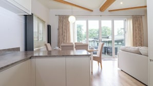 Una cocina moderna con comedor, ventanas amplias y vistas al exterior.