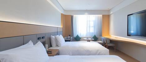 A hotel room with two beds, a desk, a chair, a television, and a window with curtains.
