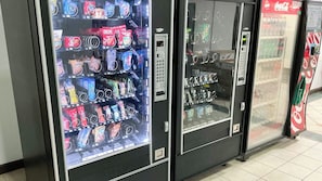 Una hilera de máquinas expendedoras con diversas opciones de comida y bebida.