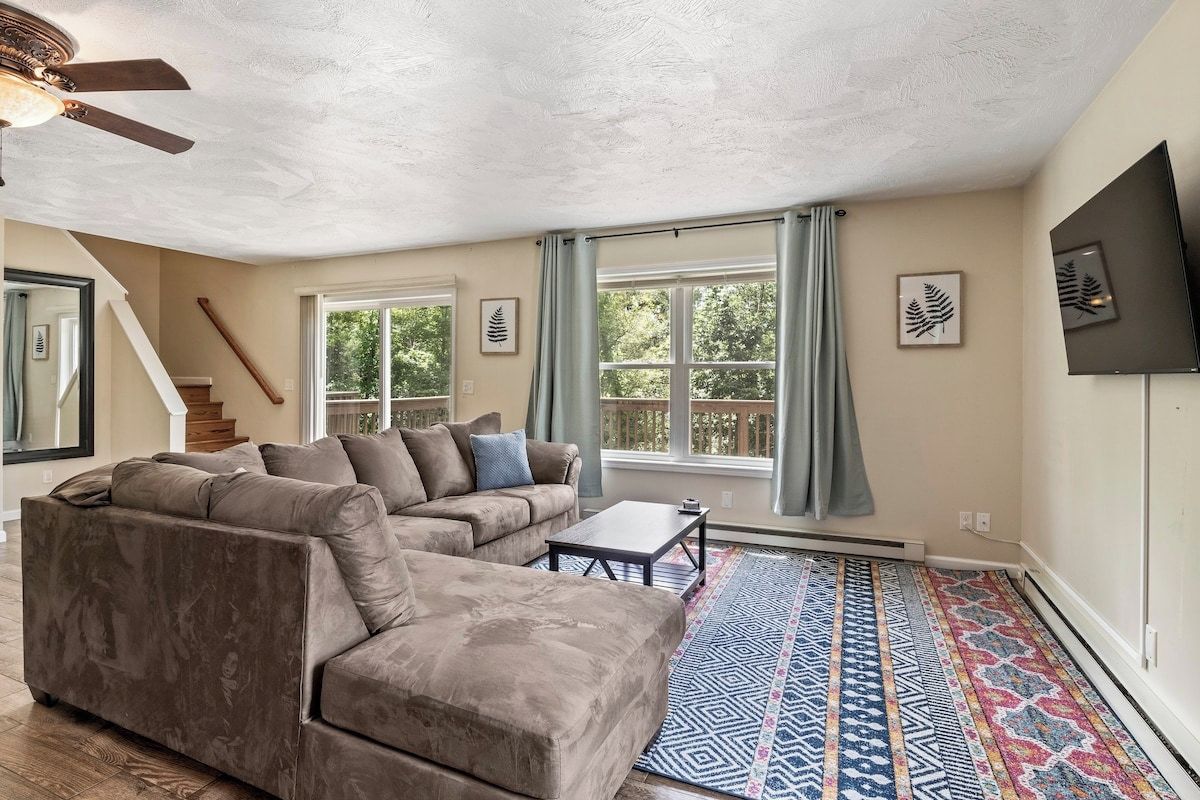 A living room with a sectional sofa, a coffee table, and a patterned rug.