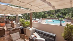 Eine Außenpatio-Bereich mit Pool, Liegestühlen und Sonnenschirmen.