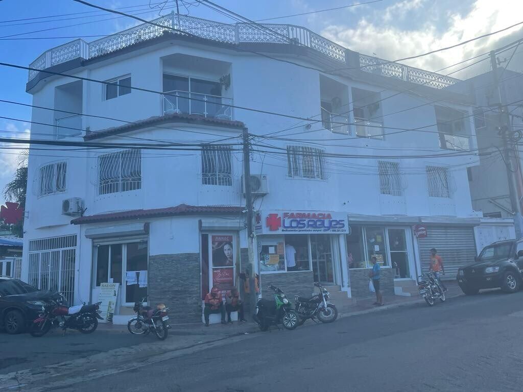 A multi-story building with a pharmacy and a restaurant on the ground floor.