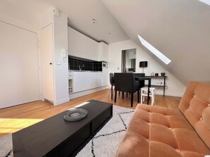 Um apartamento loft moderno com área de jantar, cozinha e uma grande janela que proporciona luz natural.