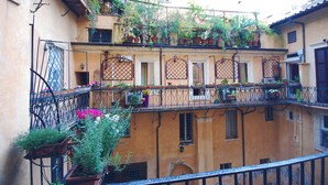 Un immeuble à plusieurs étages doté de balcons ornés de plantes et de fleurs en pot.