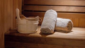 A wooden bench with a white bucket and a rolled towel.