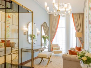 A well-lit room with a glass partition, a chandelier, a sofa, and a chair. - Mercure Alger Palais Des Congres (Algiers)