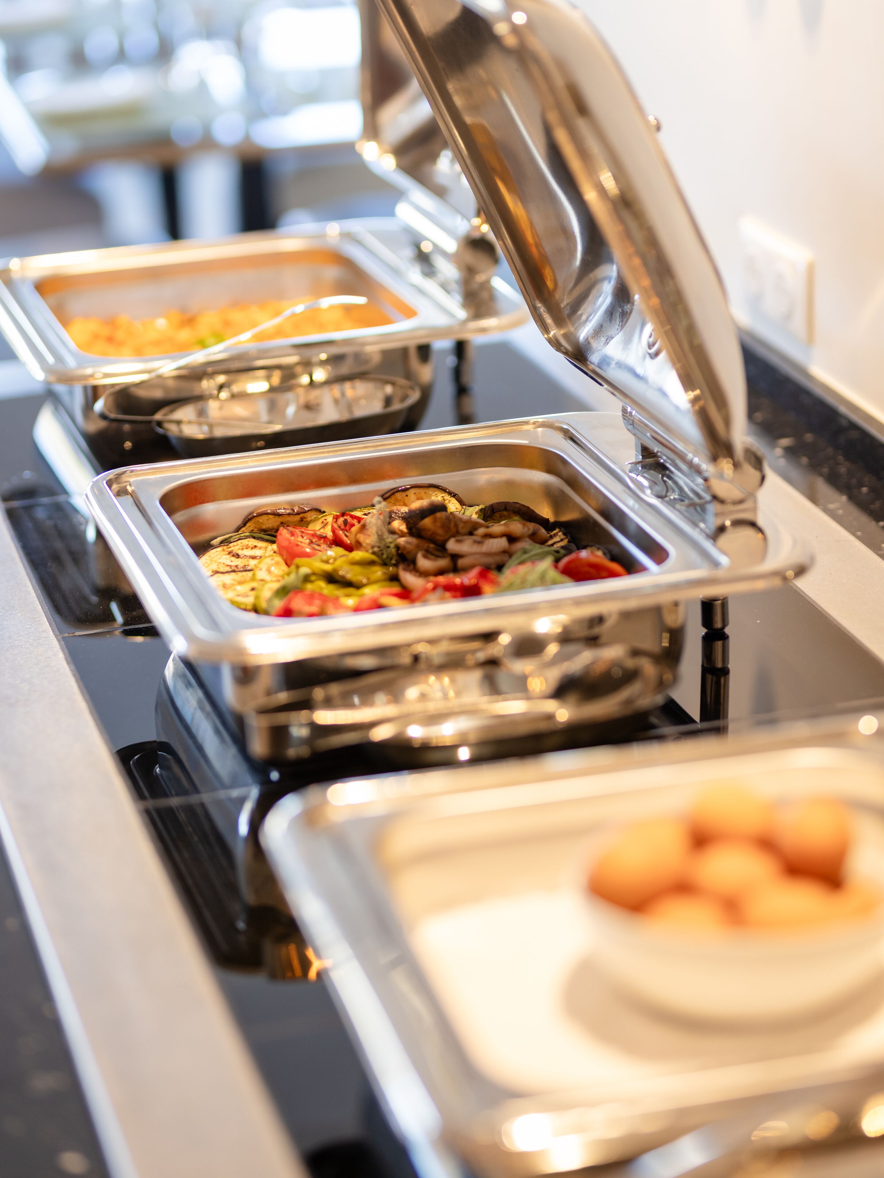 Un buffet proposant divers plats présentés dans des récipients en métal.