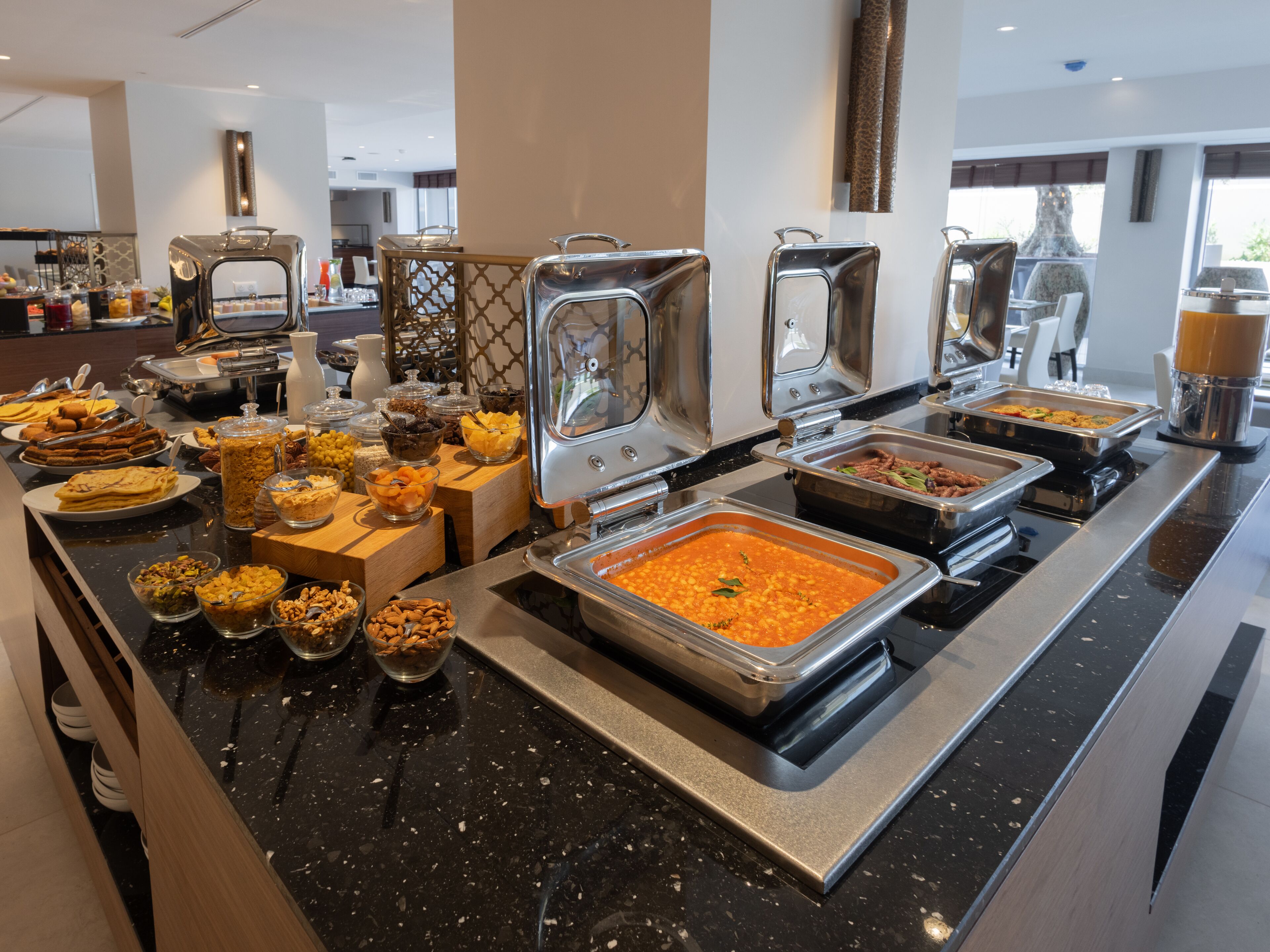 A buffet with various food options, including salads, fruits, and desserts.