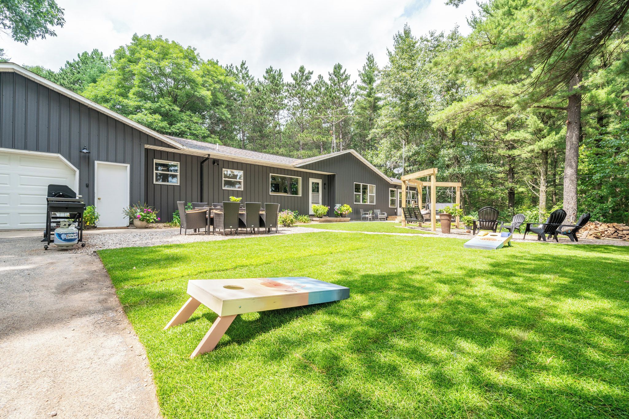 A residential property with a well-maintained lawn, a barbecue setup, and a swing set.