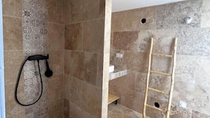 A bathroom with a shower area, a toilet, and a sink.