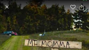 Un letrero de madera con la inscripción 'MT MOMMA' que señala hacia arriba.