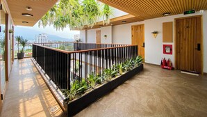 A modern interior with a wooden ceiling, a balcony with plants, a fire extinguisher, and a door marked '501'. - SALA Serviced Apartment (Đà Nẵng)