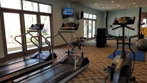 Ett gym med löpband, en motionscykel och träningsbollar.