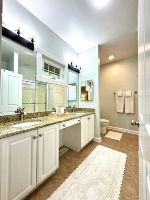 A modern bathroom with a large vanity, double sink, and a walk-in shower. - Chestnut Cottage (Highlands)