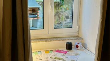Una ventana con vistas a un jardín y un banco de piedra.