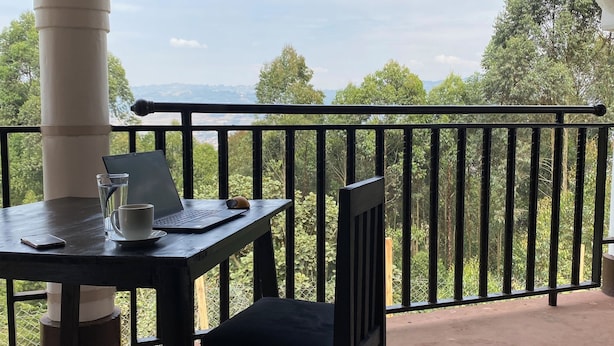 A balcony with a table, chair, and laptop. - The Fortuna Hotel and Cafe (Kabale)