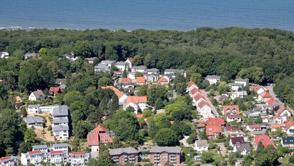 An aerial view of a residential area with houses, dense greenery, and a body of water in the background. - Baltic Sea pearl Zinnnowitz (Zinnowitz)