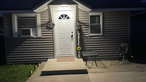 Une maison à deux étages avec une porte d’entrée, un petit porche et une boîte aux lettres.