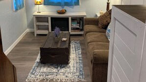 Un salon chaleureux avec une cheminée, un canapé, une table basse et un tapis.