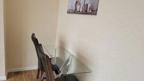 Un comedor con una mesa de vidrio y sillas de madera.