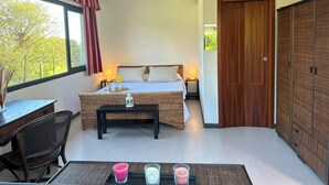 A bedroom with a bed, bedside tables, a desk, and a chair. There is a window with curtains, a door, and a view of trees outside. - Villa Biddizza 10, Emma Villas (Acireale)