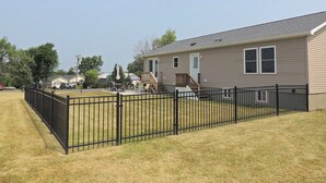A single-story house with a fenced backyard, a front porch, and a visible garage. - Cute 3BR/2BA home located in the Village of Clayton with dock rental available (Clayton)