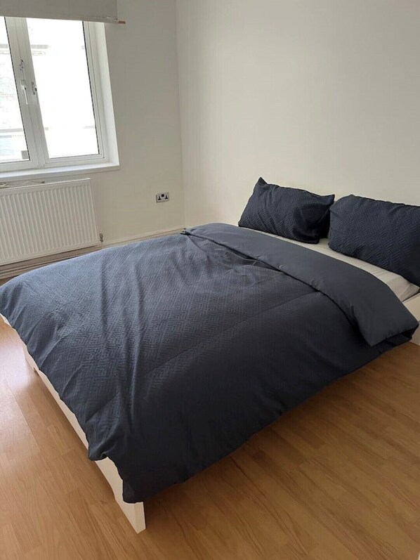 Relax in a serene bedroom with a large bed and clean, minimalist design.