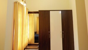 Ein Zimmer mit Deckenventilator, einem Kleiderschrank mit Spiegel und einer Deckenleuchte.