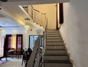 A staircase with a handrail leading to an upper floor. - Villa in Pullad, Tiruvalla (Pullad)