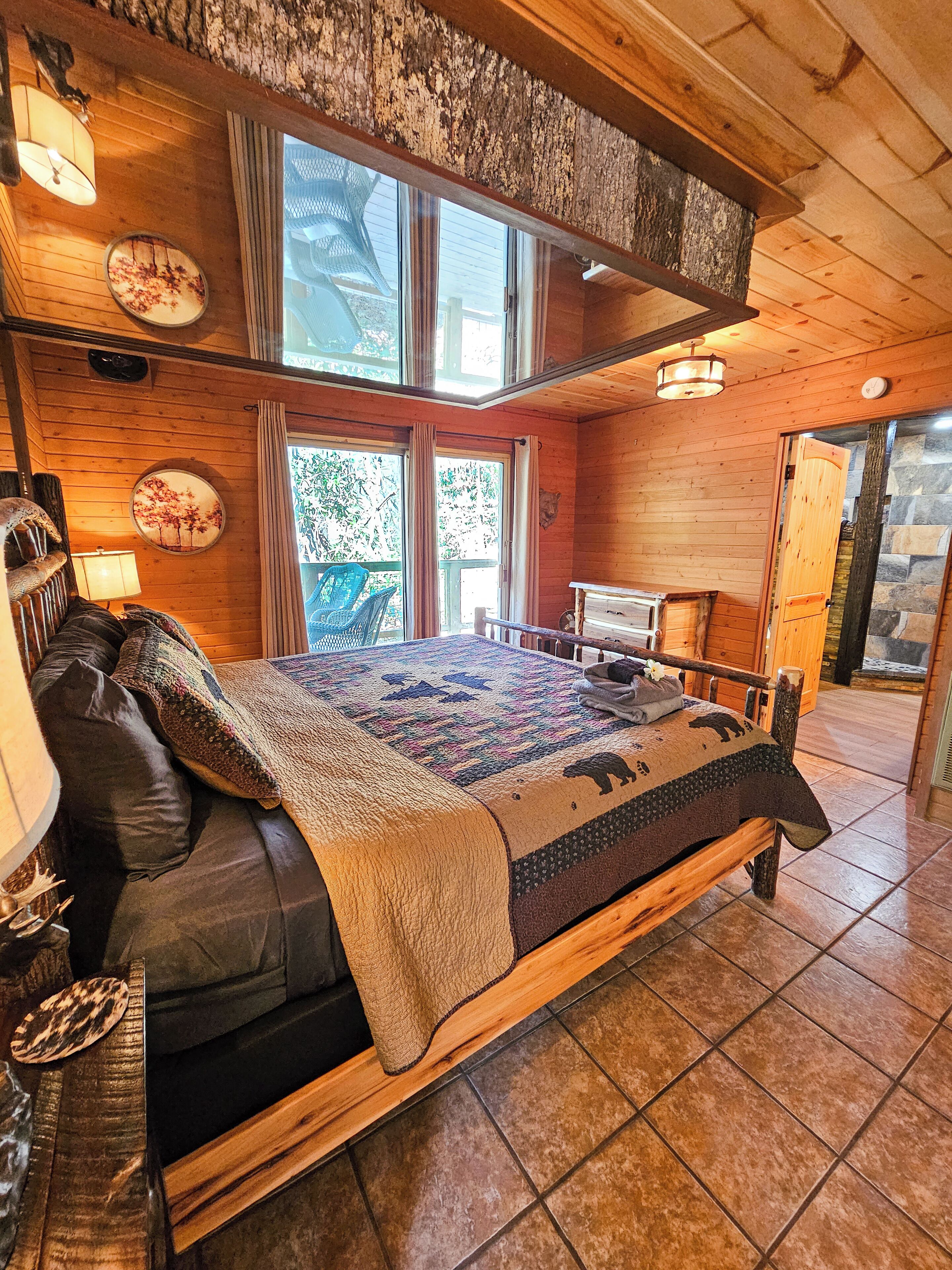 Une pièce chaleureuse, aménagée dans un chalet en bois, avec un grand lit, un banc en bois et une table à manger.
