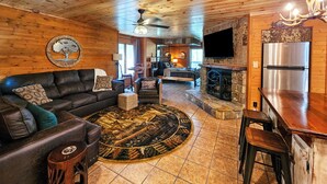 Un intérieur de chalet chaleureux comprenant un salon, un coin repas et une cuisine.