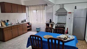 Una cocina compacta con gabinetes de madera, una estufa a gas y un refrigerador.