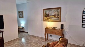 Una sala de estar con un mueble de madera, un cuadro y un televisor.