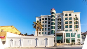 A multi-story hotel with a prominent cylindrical tower, large windows, and a grand entrance. - Ain Benian (Algiers)