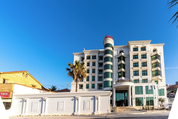 A multi-story hotel with a prominent cylindrical tower, large windows, and a grand entrance.