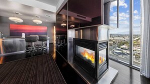 Eine moderne Bar mit Kamin, Sitzgelegenheiten und Blick auf die Stadt.