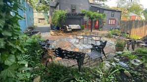 A backyard with a patio area, outdoor furniture, and a house in the background. - Silsbee's by Daniels House (Salem)