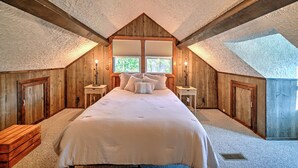 Una camera da letto con un letto grande, pareti in legno e un velux.
