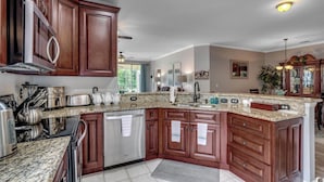 A spacious kitchen with granite countertops, stainless steel appliances, and wooden cabinetry. - Myrtle Beach Legends Golf Condo, on course! 3BR/2BA, pool, hot tub, and tennis. (Myrtle Beach)