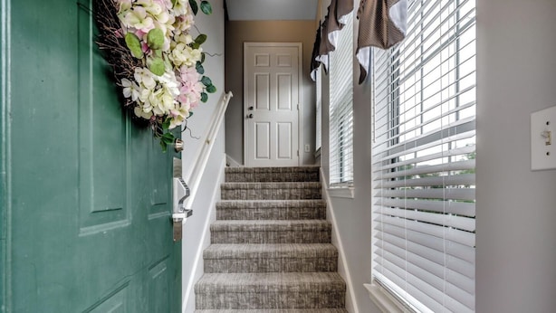 A staircase with a green door, a white door, and a window with blinds. - Myrtle Beach Legends Golf Condo, on course! 3BR/2BA, pool, hot tub, and tennis. (Myrtle Beach)