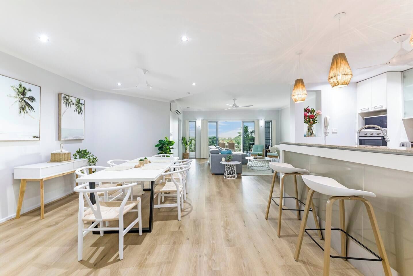A modern, open kitchen features an island bench with a breakfast bar for casual dining