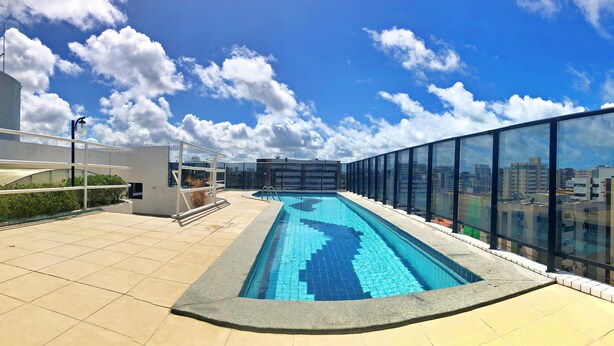 Una piscina en la azotea con vistas despejadas del horizonte urbano.