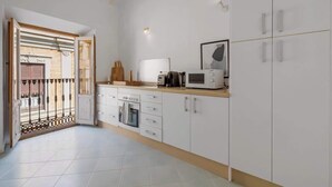 A modern kitchen with white cabinets, a microwave, and a coffee maker on the countertop. - Penthouse in Málaga by Costarentals - MAL01 (Málaga)