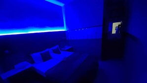 Une pièce comprenant un lit, une petite table et un téléviseur fixé au mur.