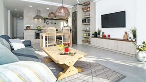 A modern living room with a sofa, a dining table, and a kitchen area in the background. - Beachclose apt Marbella by Costarentals - M28 (Marbella)