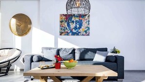 A modern living room with a wooden coffee table, a grey sofa, and a colorful abstract painting on the wall. - Beachclose apt Marbella by Costarentals - M28 (Marbella)