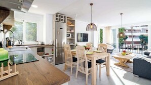 A modern kitchen with a dining area, a large window, and a balcony with outdoor furniture. - Beachclose apt Marbella by Costarentals - M28 (Marbella)